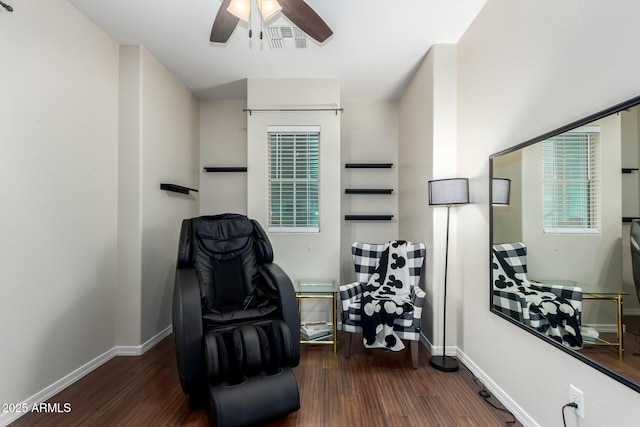 sitting room with dark wood-type flooring and ceiling fan