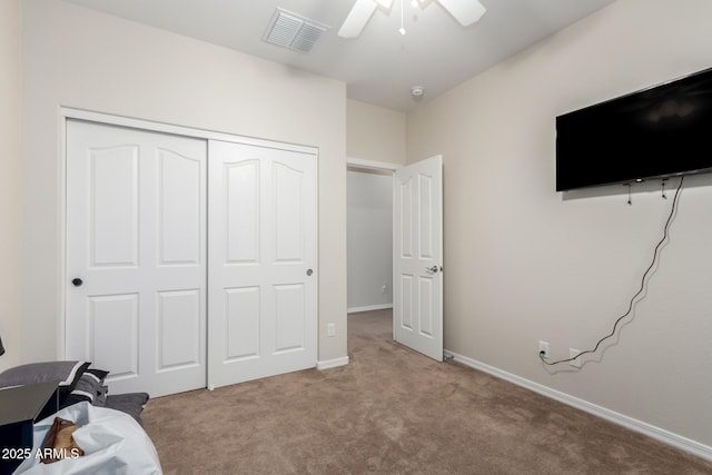 unfurnished bedroom with light carpet, ceiling fan, and a closet