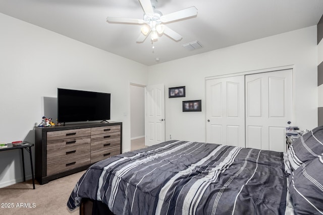 bedroom featuring light colored carpet, a closet, and ceiling fan