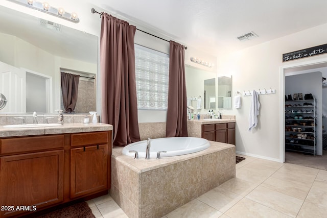 bathroom featuring vanity, tiled tub, and tile patterned floors