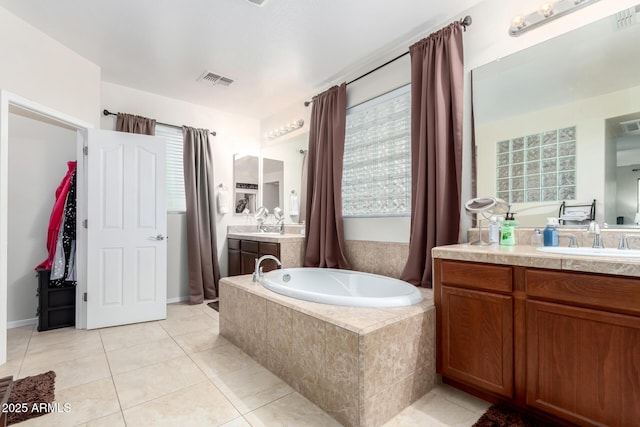 bathroom featuring vanity, tile patterned floors, and tiled bath