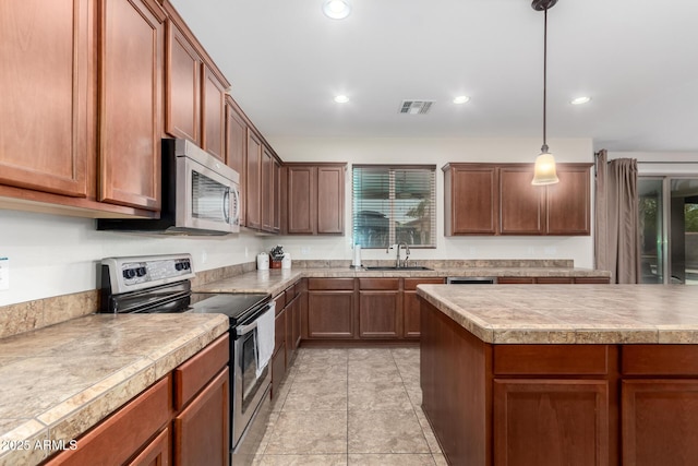 kitchen with hanging light fixtures, stainless steel appliances, sink, and a healthy amount of sunlight