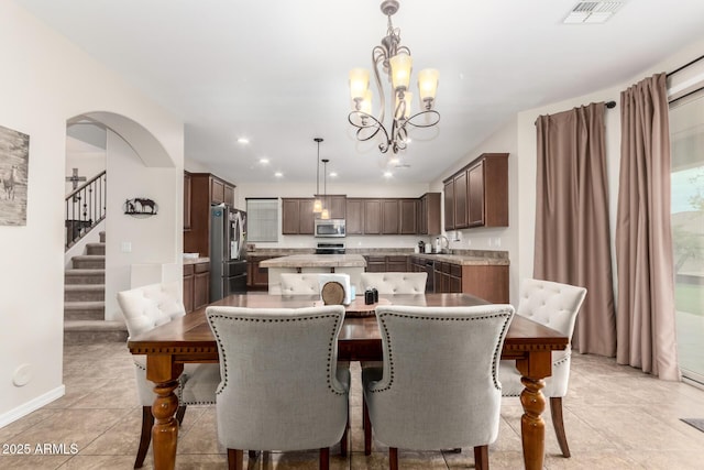 tiled dining space with sink and a chandelier