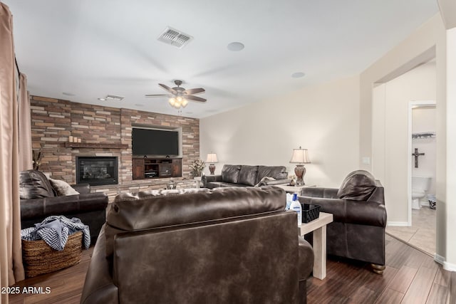 living room featuring ceiling fan, dark wood-type flooring, and a fireplace