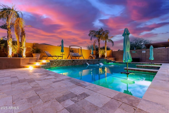 pool at dusk featuring a patio area