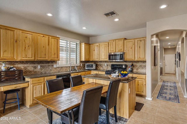 kitchen featuring light tile patterned floors, sink, a kitchen island, and black appliances