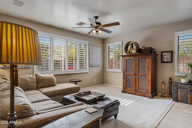 living room with a textured ceiling and ceiling fan