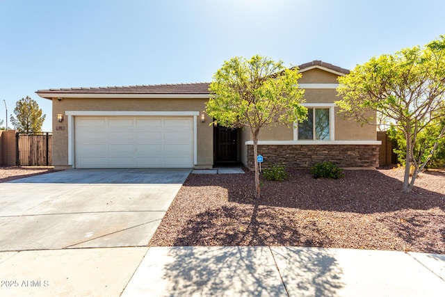 ranch-style house with fence, driveway, an attached garage, stucco siding, and stone siding