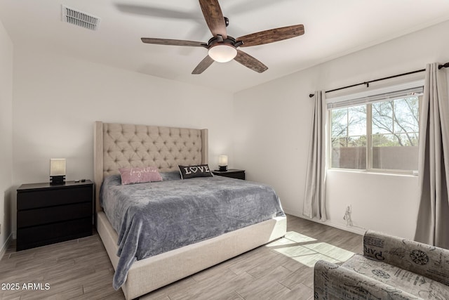 bedroom with a ceiling fan, wood finished floors, and visible vents