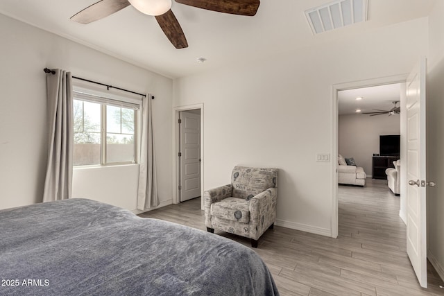 bedroom featuring visible vents, a ceiling fan, light wood-type flooring, and baseboards