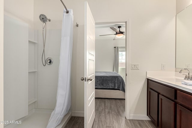 ensuite bathroom featuring connected bathroom, ceiling fan, a shower with shower curtain, wood finished floors, and vanity