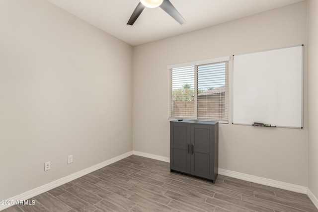 unfurnished room with a ceiling fan, baseboards, and wood tiled floor