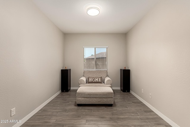 sitting room with baseboards and wood finished floors