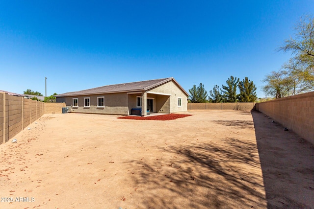 rear view of house featuring stucco siding, a patio, and a fenced backyard