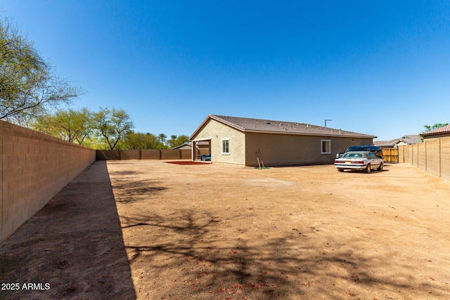 view of side of home with stucco siding, a patio, and a fenced backyard