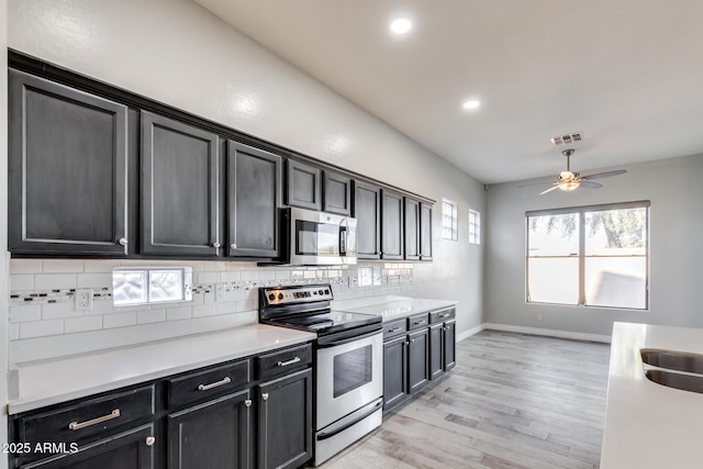 kitchen with tasteful backsplash, stainless steel appliances, light hardwood / wood-style floors, and ceiling fan