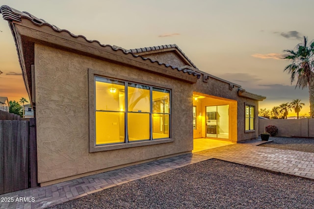 property exterior at dusk with a patio