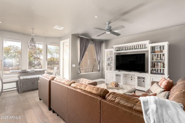 living room with light wood-style floors, ceiling fan, and visible vents