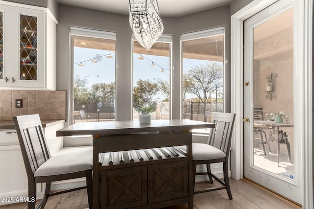 dining area featuring light wood-style floors and a notable chandelier