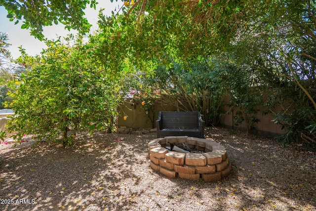 view of yard with fence and a fire pit