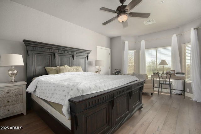 bedroom featuring hardwood / wood-style floors, visible vents, and baseboards