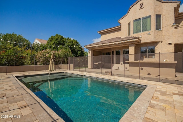 view of swimming pool featuring a patio, fence, and a fenced in pool