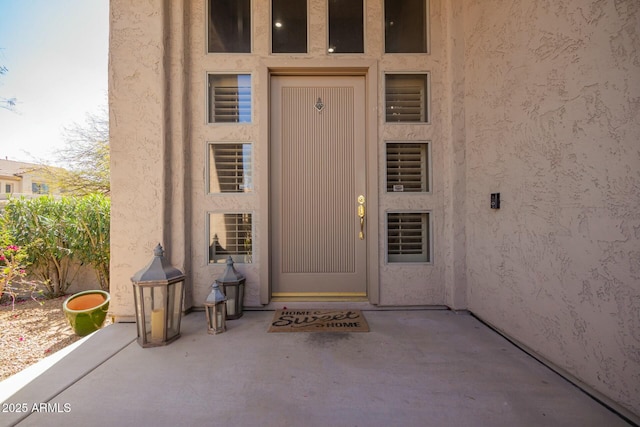 doorway to property featuring a patio area and stucco siding