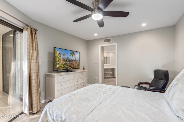 bedroom featuring ceiling fan, ensuite bathroom, and light hardwood / wood-style flooring