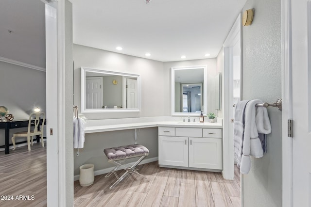 bathroom featuring hardwood / wood-style floors, vanity, and ornamental molding