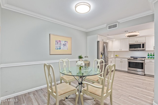 dining area with light hardwood / wood-style flooring and crown molding