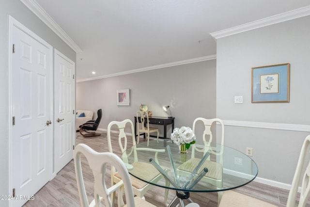 dining area with light hardwood / wood-style floors and ornamental molding