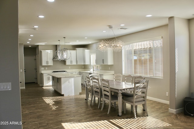 dining area featuring dark hardwood / wood-style floors, sink, and a chandelier