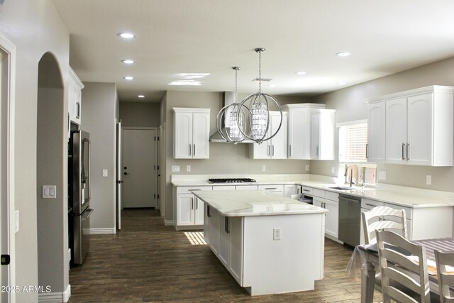 kitchen featuring white cabinetry, a kitchen island, stainless steel appliances, and decorative light fixtures