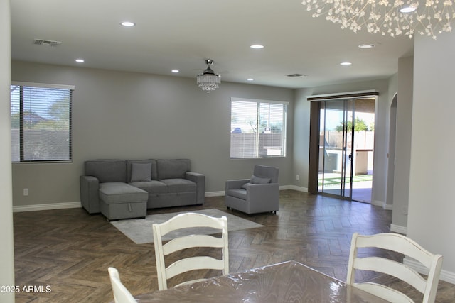 living room featuring a chandelier and dark parquet flooring