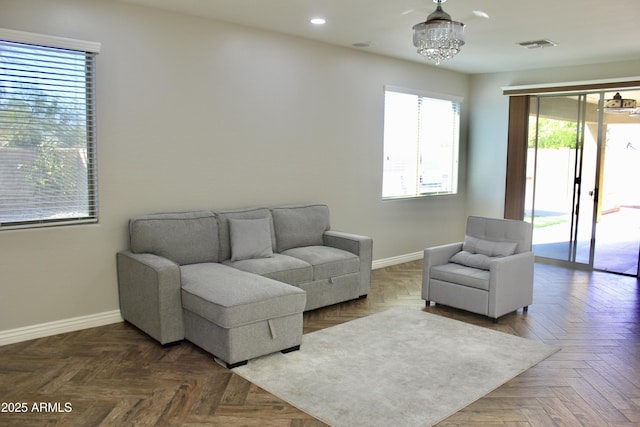 living room with a notable chandelier and dark parquet flooring