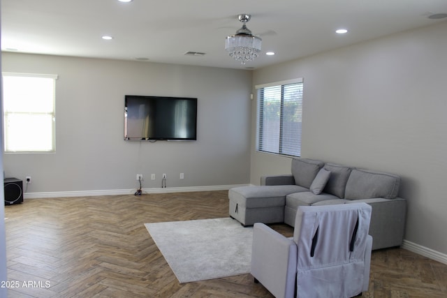 living room featuring parquet flooring, a chandelier, and plenty of natural light