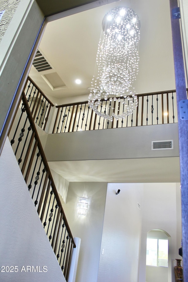 stairs featuring a high ceiling and an inviting chandelier