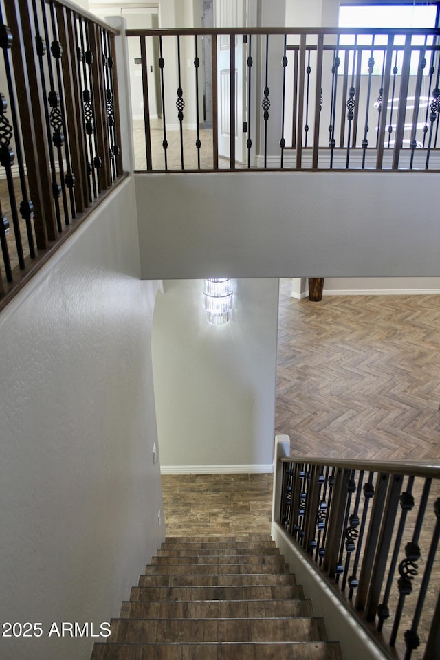 stairs with a chandelier and parquet flooring