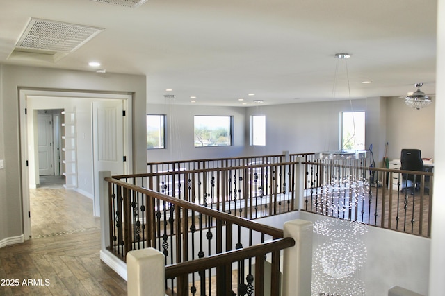 hall with parquet flooring, an inviting chandelier, and plenty of natural light