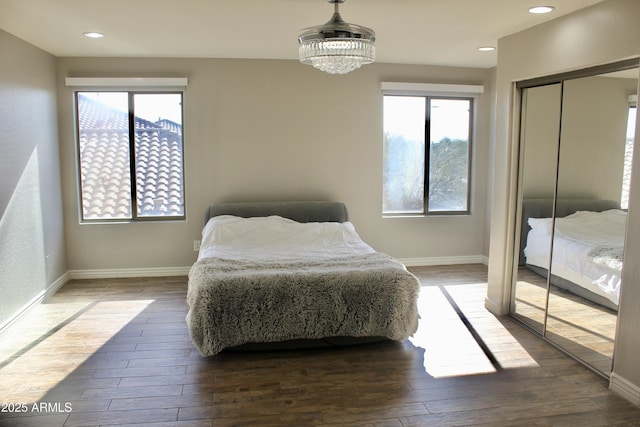 bedroom featuring a chandelier, dark hardwood / wood-style floors, and a closet