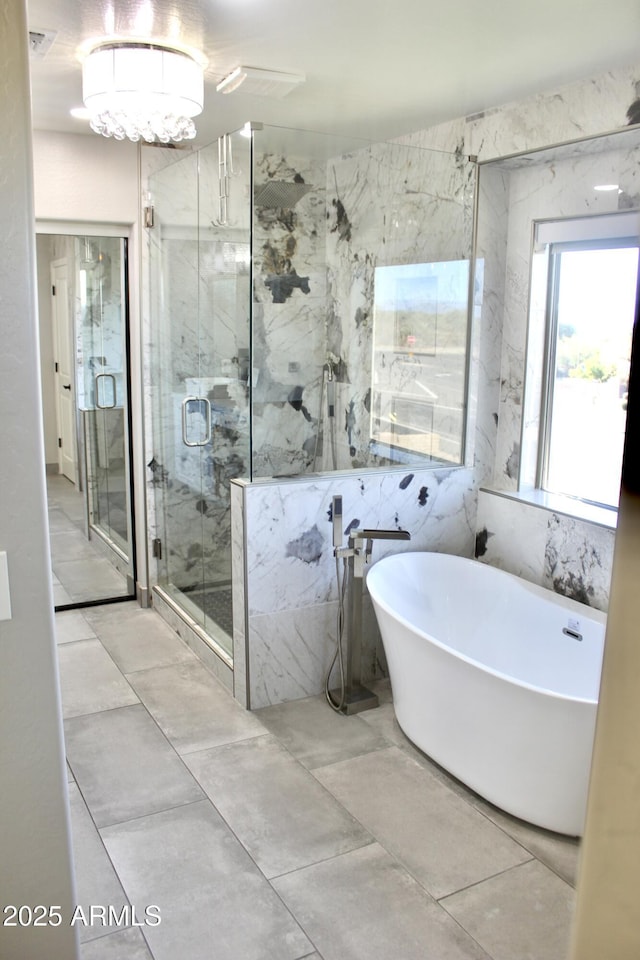 bathroom featuring plus walk in shower and tile walls