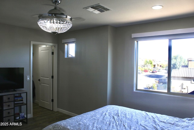 bedroom with a chandelier and dark hardwood / wood-style floors