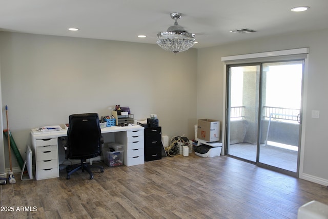 office area with an inviting chandelier and dark wood-type flooring