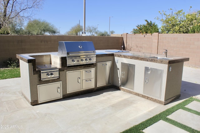 view of patio with sink, area for grilling, and a grill