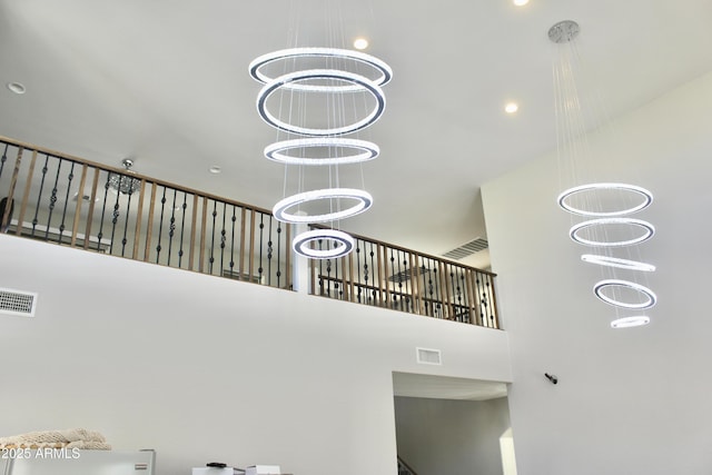 staircase featuring a high ceiling and an inviting chandelier