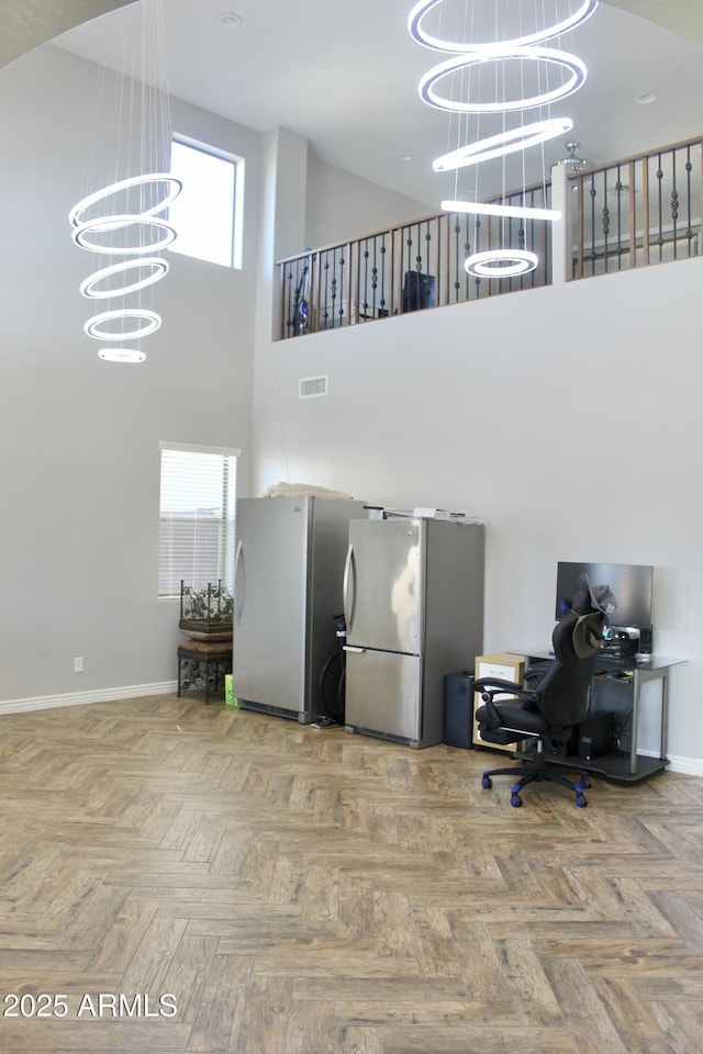 interior space with parquet floors, a chandelier, and a high ceiling