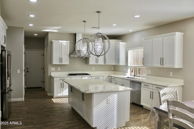 kitchen with pendant lighting, white cabinets, a kitchen island, stainless steel appliances, and extractor fan