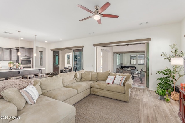 living room with light wood finished floors, a ceiling fan, visible vents, and recessed lighting