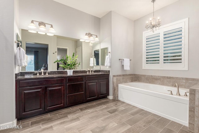 bathroom with vanity, a tub to relax in, and an inviting chandelier