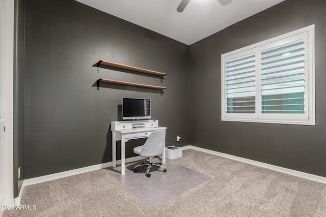 carpeted home office featuring ceiling fan